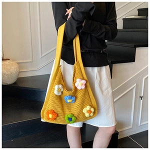 Détail d'un sac en tricot jaune orné de fleurs colorées en crochet 3D élégantes