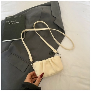 Detailed close-up of light beige pleated cloud bag with soft faux leather texture