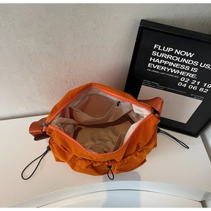 Top-down view of orange nylon crossbody bag interior with zipper pocket and compartments