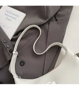 Détail de la bandoulière large réglable avec boucle argentée sur un sac croissant