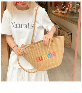 Close-up of summer embroidery on a large beige woven straw tote bag for beach vacations