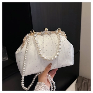 Détail de pochette plissée blanche avec strass, fermoir fleur dorée et chaîne de perles