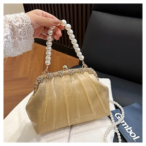 Détail de la pochette de soirée à paillettes dorées avec poignée en perles et cadre floral