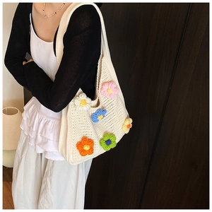 Vue détaillée du sac crocheté blanc orné de fleurs 3D colorées et d'une bandoulière