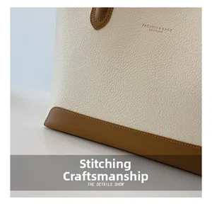 Detailed macro view of the cream leather texture and precision stitching on a tote bag
