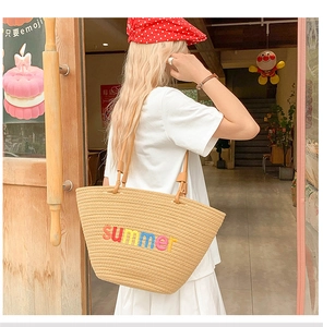 Detail of hand-woven summer tote bag with rainbow embroidery and leather shoulder straps