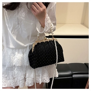 Détail du sac en velours noir à pois avec anse en perles et fermoir en cristal doré