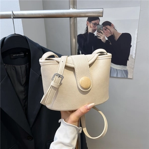 Minimalist beige soft faux leather bucket bag with silver buckle and crossbody strap