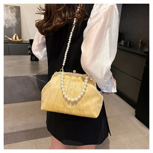 Détail du sac de soirée élégant en perles jaune pâle avec tissu plissé et fermoir strass