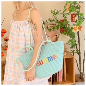 Detail of mint green woven tote bag with rainbow Summer embroidery and slim handles