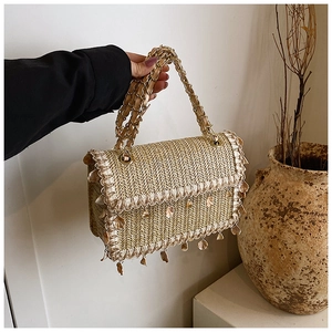 Détail du sac en paille tissé avec franges en coquillage et bandoulière à chaîne