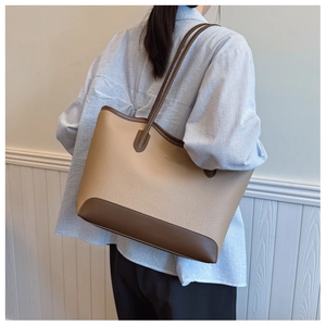 Detailed view of spacious two-tone tote bag in beige and brown pebbled leather