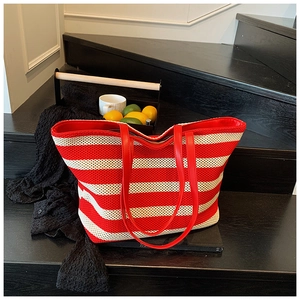 Macro detail of red and white striped woven tote bag with durable leather handles