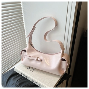 Detail of light pink patent leather baguette bag with side pockets and glossy finish