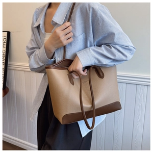 Detail of contrast-colored tote bag with lychee texture and slim shoulder straps