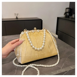 Détail de la pochette dorée champagne avec fermoir fleur strass et chaîne perlée