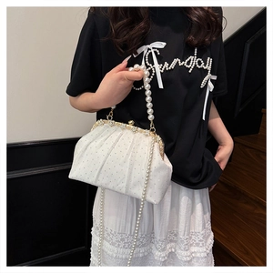 Pochette plissée blanche avec perles et strass portée par un mannequin, style rétro chic