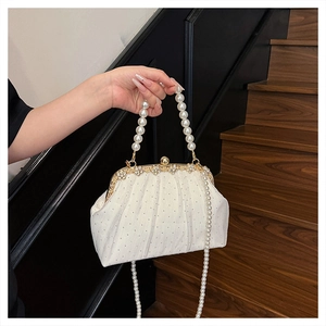 Détail de la pochette de soirée blanche avec strass, anse en perles et fermoir fleuri
