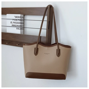 Detail of color-block tote bag showing lychee grain leather and fashion embossed text