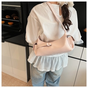 Detail view of pink underarm bag in glossy leather with side pocket and wide strap