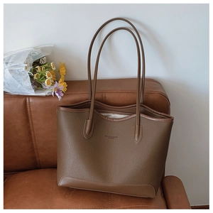 Detailed shot of brown litchi pattern tote bag leather texture with embossed logo