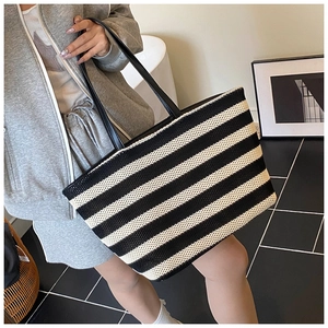 Detail of black and white striped woven tote bag with slim shoulder straps for summer