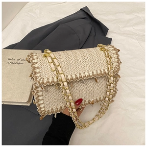 Détail du sac en paille tressée avec motif à chevrons et franges de coquillages