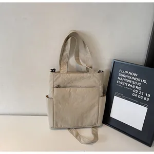 Detail view of khaki nylon tote bag with side pockets and textured fabric finish