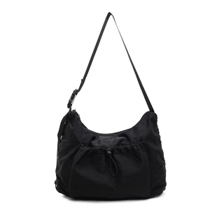 Minimalist black nylon crossbody bag with adjustable strap and functional drawstring pocket