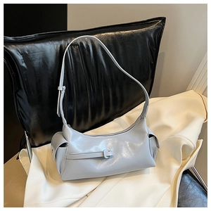 Detail view of light blue patent leather shoulder bag with side pockets and decorative buckle