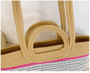 Detail of multi-color woven tote bag featuring pink stripe and dual handle design