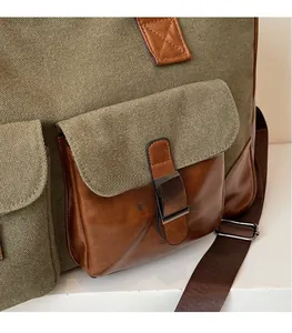 Detail of military green canvas and brown leather pocket with metal buckle on travel bag