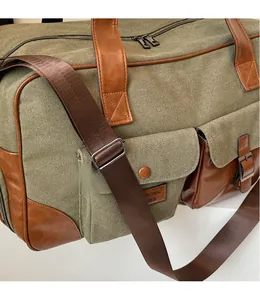 Detail of adjustable canvas strap and faux leather trim on green travel duffel bag