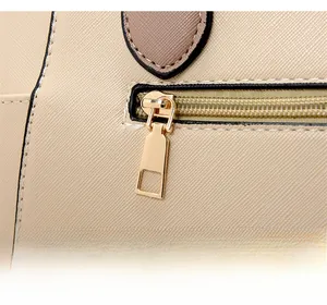 Close-up of golden zipper hardware on cross-grain leather of stylish shoulder bag