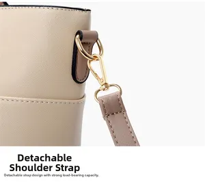 Close-up of detachable shoulder strap with gold metal hook on beige Saffiano leather bag
