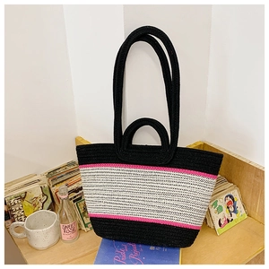 Detail of hand-woven tote bag showing tri-color striped texture and dual handles