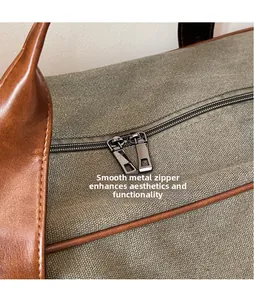 Detail of olive canvas travel bag with smooth metal zipper pulls and leather accents