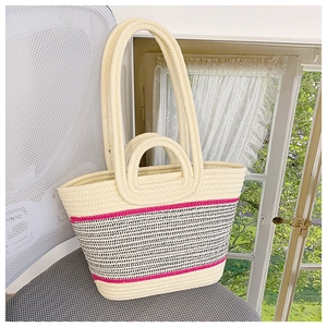 Detailed macro view of woven tote bag texture with pink stripes and multiple handle design