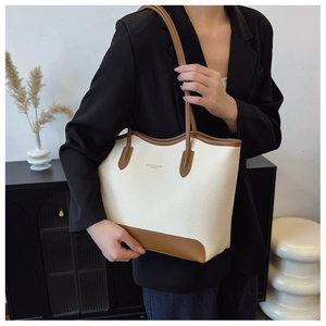 Detailed shot of contrast color tote bag showing lychee grain leather texture and handle