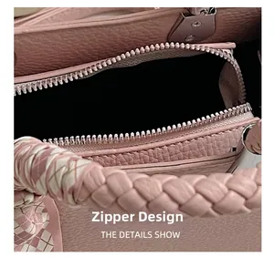 Detailed close-up of pink litchi leather texture with woven handle and plaid silk scarf