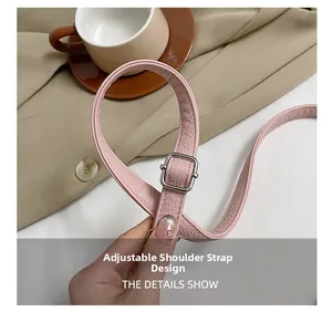 Detail of pink lychee leather adjustable shoulder strap with silver buckle on a handbag