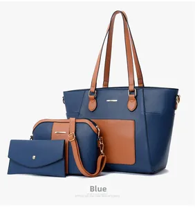 Three-piece tote bag set in navy blue and brown leather with gold hardware detail