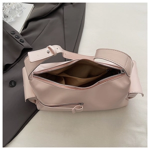 Top view of open pink leather baguette bag showing interior compartments and zipper pocket