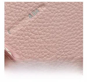 Detailed macro view of pink lychee grain leather texture with quilted fabric lining