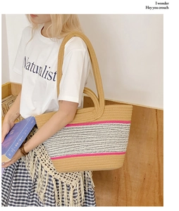 Detail of hand-woven straw tote with pink and white stripes for beach use