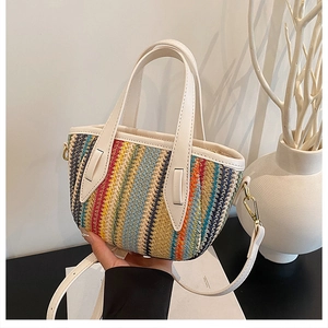 Detail of colorful striped woven bag with white leather straps and gold metal hardware