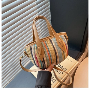 Detailed close-up of colorful striped woven beach bag with premium brown leather handles