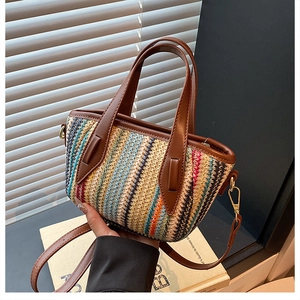 Detail of colorful striped woven tote bag with brown leather handles and adjustable strap