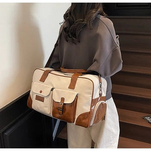 Detail of canvas travel bag with side cylindrical zipper pocket and leather stitching