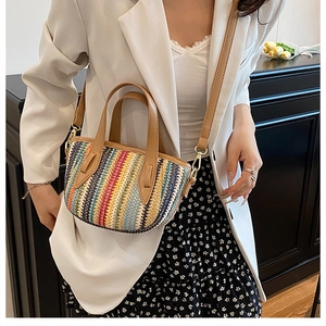 Detail of colorful striped woven bag with leather handles and detachable shoulder strap